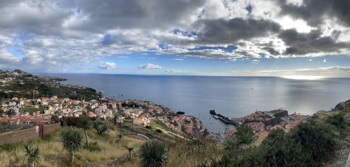 Panorama of Madeira, featuring the city of Funchal, the coastline, and the island's rugged peaks in the distance